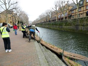 Photo of volunteers launching a vegetated raft into a canal